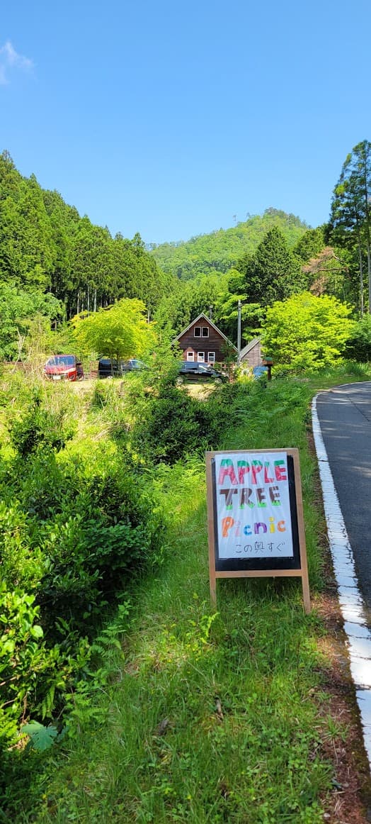 アップルツリーファミリーピクニックの案内看板と山の中の家